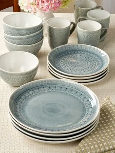 a table topped with plates and cups filled with flowers