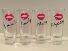 four shot glasses with red lips and names on the glass are lined up in a row