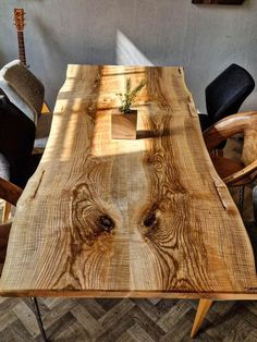 a wooden table with chairs around it and a plant growing out of the center piece