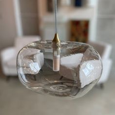 a clear glass light fixture hanging from a ceiling in a living room or dining room