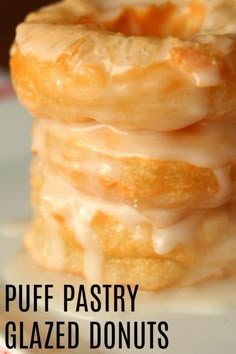 a stack of glazed donuts sitting on top of a white plate with the words puff pastry glazed donuts