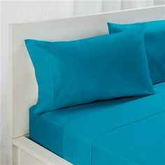 a bed with blue sheets and pillows on it