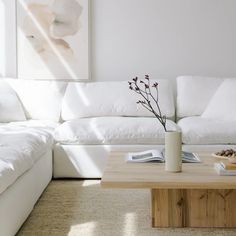 a living room with white couches and a coffee table in front of the couch