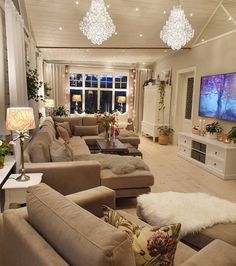 a living room filled with furniture and a flat screen tv mounted on the wall next to a fire place