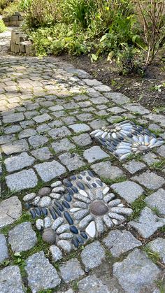 a cobblestone walkway with stepping stones in the middle