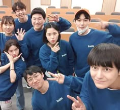 a group of young people standing next to each other in front of a lecture hall