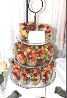 a tiered tray filled with lots of fruit on top of a table