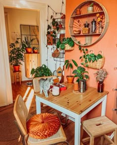 a table with some plants on top of it and two stools next to it