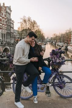 a man and woman are hugging on a bike