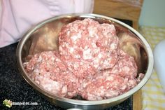 a metal bowl filled with meat sitting on top of a counter