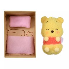 a winnie the pooh stuffed animal in a box next to it's packaging