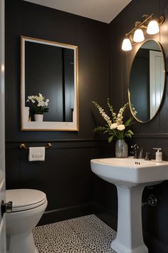 a white toilet sitting next to a sink in a bathroom under a mirror and lights