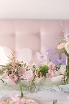 the table is set with flowers and plates