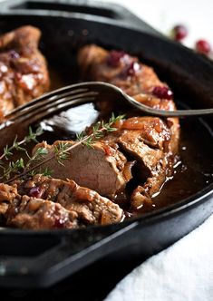 meat and gravy in a cast iron skillet with a fork resting on it