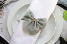 a white plate topped with a gray bow napkin