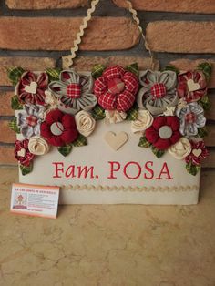 a sign that says fam posa with flowers and hearts hanging on the wall