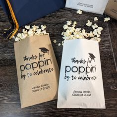 two bags filled with popcorn sitting on top of a wooden table