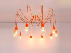 an orange chandelier hanging from the ceiling with five light bulbs attached to it