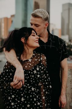 a man and woman standing next to each other in front of a tall building with stars on it