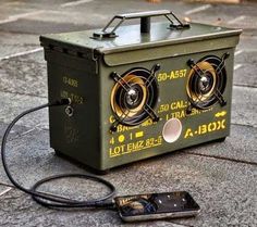 a speaker box sitting on the ground next to a cell phone