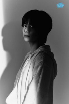 a black and white photo of a woman in a hoodie looking up at the camera