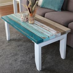 a coffee table made out of wood and painted white with blue paint on the top