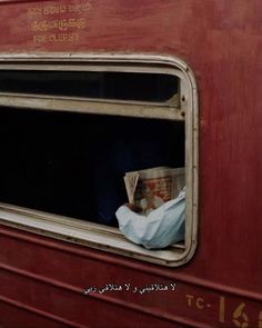 an open window on the side of a red train