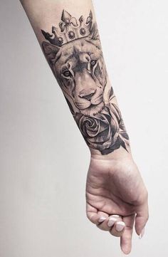 a woman's arm with a tattoo on it and a lion wearing a crown