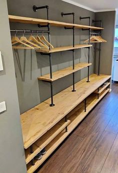 an empty walk in closet with wooden shelves and metal rails on the wall, next to a hardwood floor