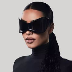 a woman in black is wearing a cat - eye mask