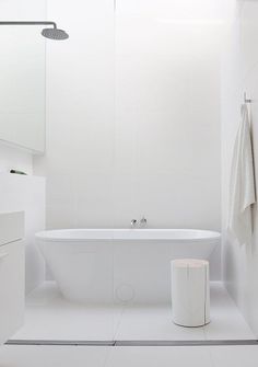 a white bathroom with a bathtub and toilet