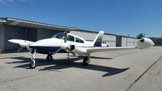 a small airplane parked in front of a hangar