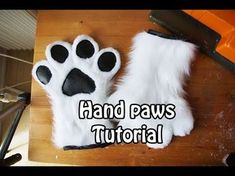 there is a cat paw that has been placed on top of a wooden table with the words hand paws