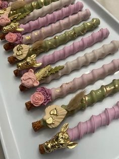 there are many different colored toothbrushes lined up on the trays with gold and pink flowers