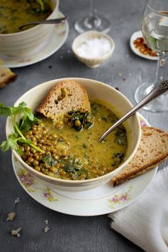 there is a bowl of soup with bread on the table