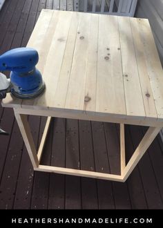 a table made out of wood with a sander on it and a power drill