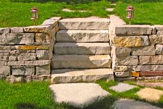 stone steps leading up to a grassy area with two lanterns on each side and green grass in the background