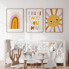 a baby's room with three pictures hanging on the wall and two children's chairs