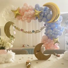 a table with balloons, stars and moon decorations