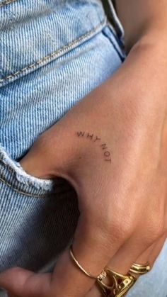 a person with a small tattoo on their left hand and the word love is written in cursive writing