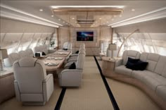 the inside of an airplane with tables and couches on each side, along with other seating areas