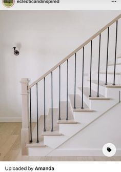 a white staircase with black handrails in an empty room