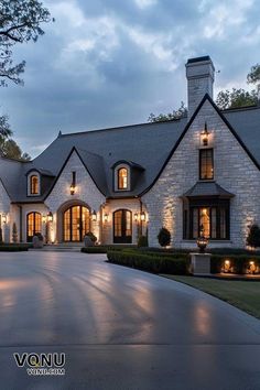 a large white house with lots of windows and lights on it's front entrance