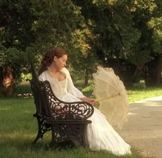 a woman sitting on a bench holding an umbrella