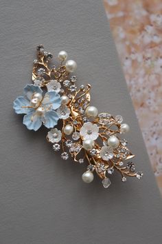 Small bridal hair clip  wedding hair piece Prom hair Colour: champagne  gold  tone/clear/ivory/lt. blue. Size approx 3.5 inches, width approx 1.5 inches. Materials: metal findings, faux pearls, beads, lt.blue paper flower, small lucite flowers, wire, alligator clip. This listing for one hair clip (similar blue headpieces available in other listings) SIMPLE PACKAGING. MORE SOMETHING BLUE (see last pictures): https://www.etsy.com/uk/shop/DonataleBridal?ref=seller-platform-mcnav&search_query=blue MORE hair accessories: https://www.etsy.com/uk/shop/DonataleBridal?ref=seller-platform-mcnav&search_query=hair Wedding JEWELRY: https://www.etsy.com/uk/shop/DonataleBridal?ref=seller-platform-mcnav&section_id=19125584 Wedding SASHES: https://www.etsy.com/uk/shop/DonataleBridal?ref=seller-platform-mcn Bridal Hair Jewelry Head Pieces, Blue Flower Wedding, Wedding Flower Hair Pieces, Flower Wedding Hair, Hair Piece Wedding Hair, Bridesmaid Hair Comb, Wedding Hair Clip, Floral Hair Comb, Hair Piece Wedding