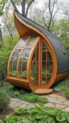 an unusual house made out of wood and glass in the middle of a garden area