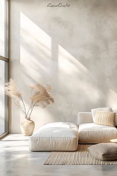 a living room with a white couch and pillows on the floor next to a large window