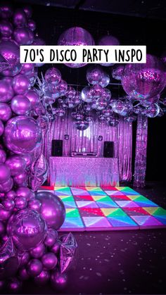 a dance floor with purple balloons hanging from it's ceiling and disco ball decorations in the background