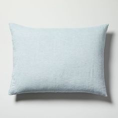 a light blue pillow on a white wall