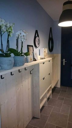 a room with several vases and pictures on the wall next to a blue door